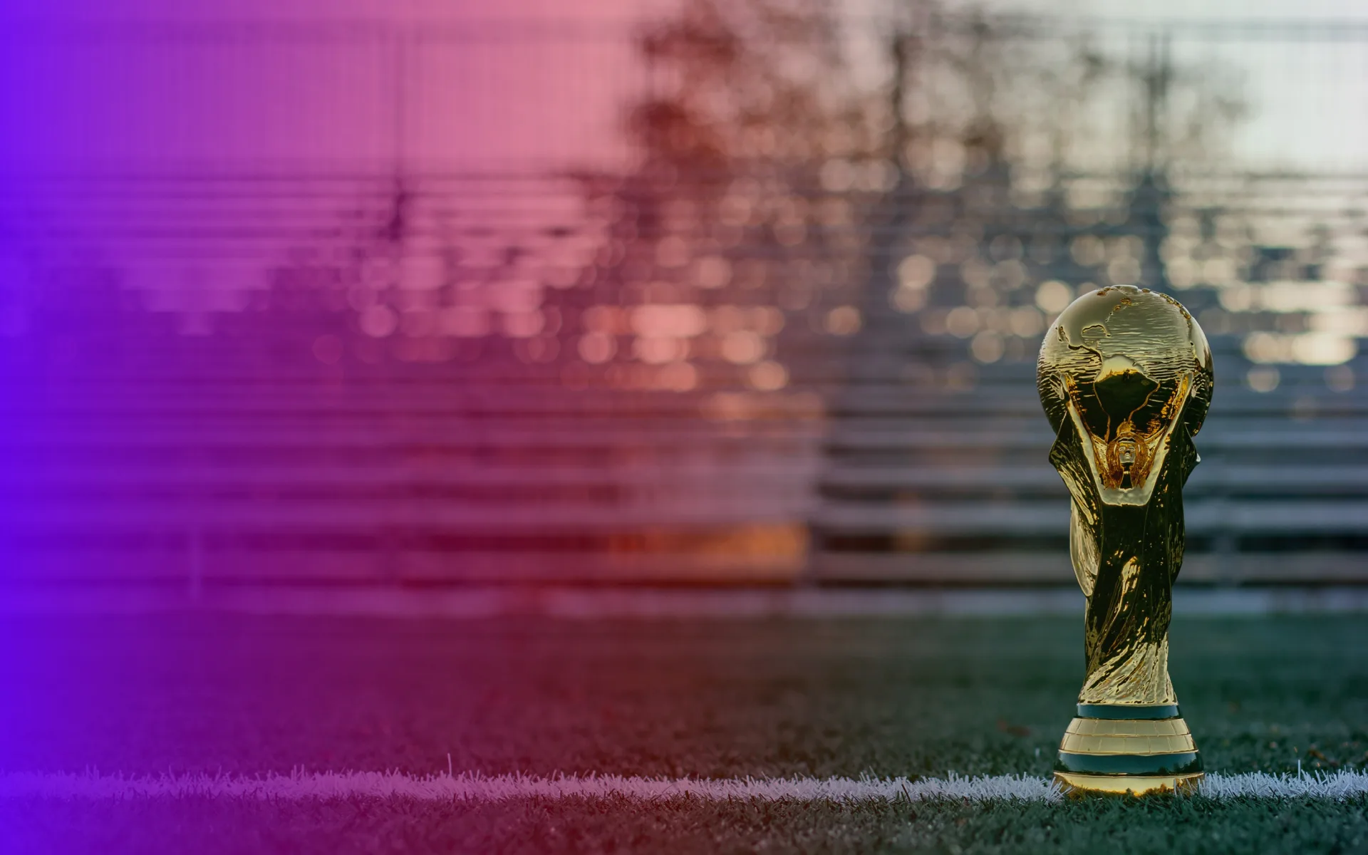 FIFA World Cup trophy on a pitch at dusk